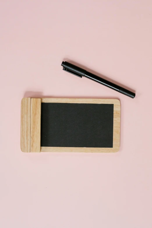 a blackboard and a pen on a pink background, holding a wood piece, rounded corners, 🎀 🍓 🧚, no text