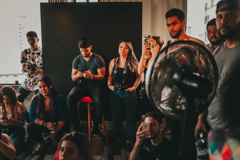 a group of people sitting and standing in a room, a portrait, pexels contest winner, charlie bowater and artgerm, paparazzi shot, panel of black, photoshoot for skincare brand