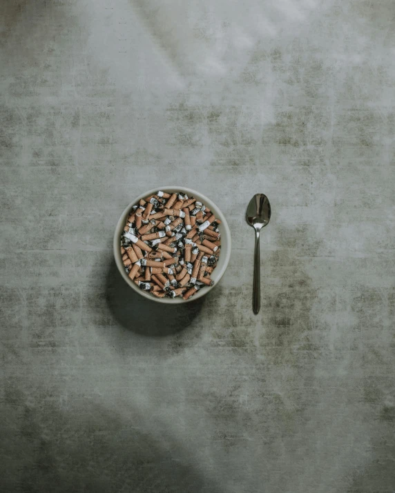 a bowl of pills and a spoon on a table, by Emma Andijewska, pexels contest winner, hyperrealism, grey backdrop, cinnamon, full body image, dark sky