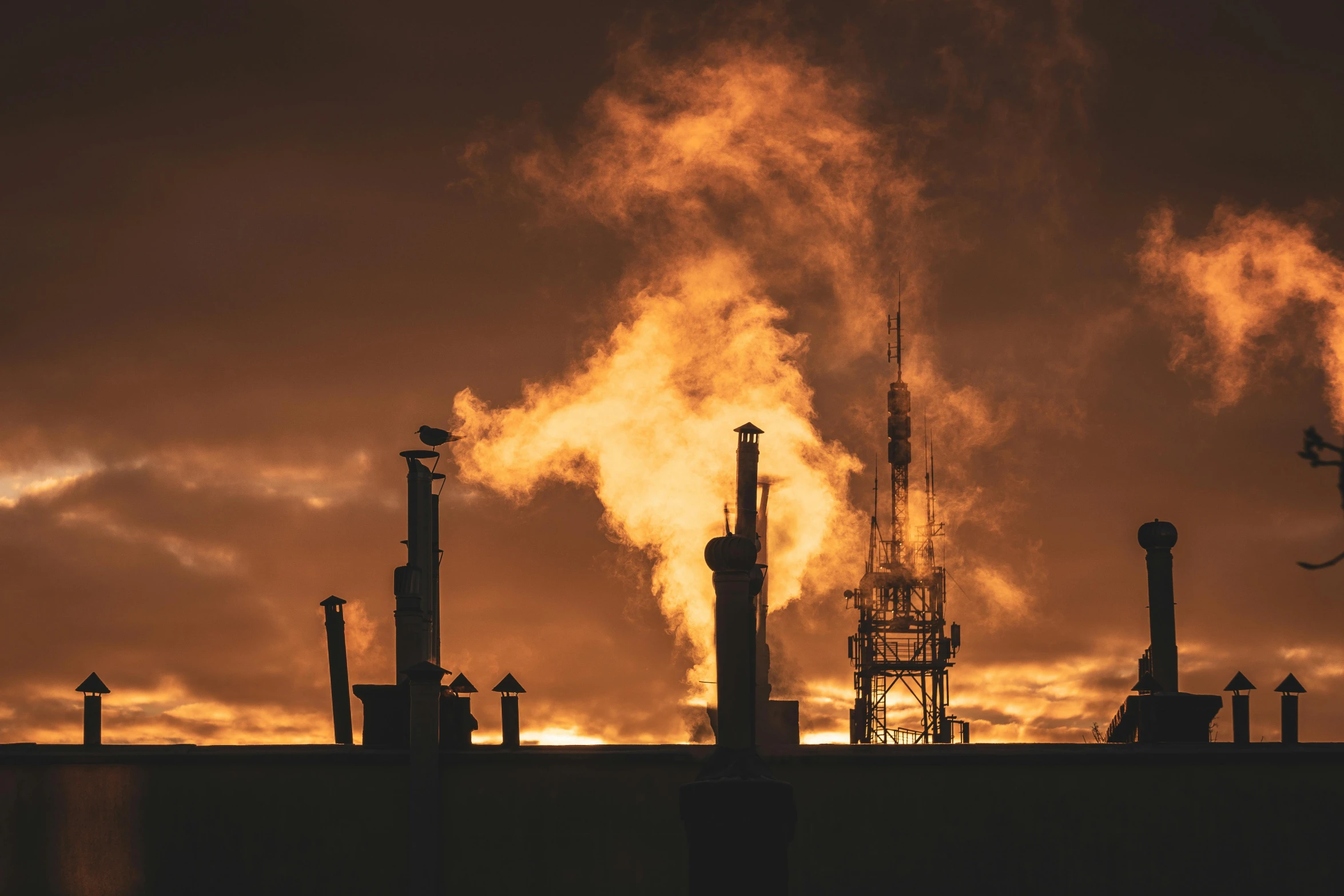 a factory with a lot of smoke coming out of it, by Lee Loughridge, pexels contest winner, orange sky, gas, high-contrast, chimneys on buildings