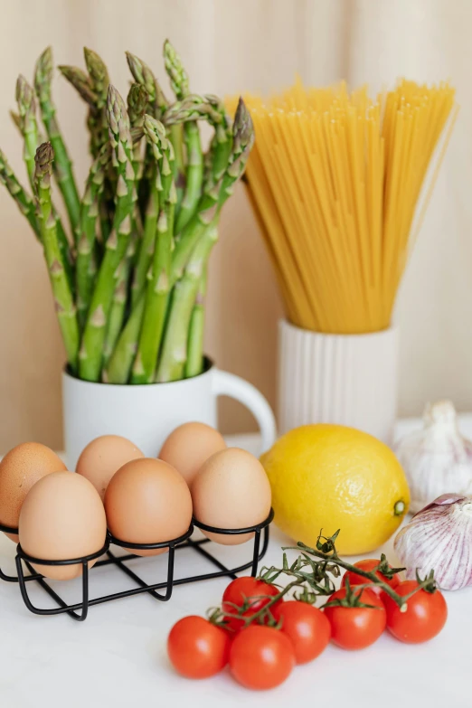 a table topped with eggs, asparagus and tomatoes, a still life, trending on pexels, kitchen background, rack, first light, pasta