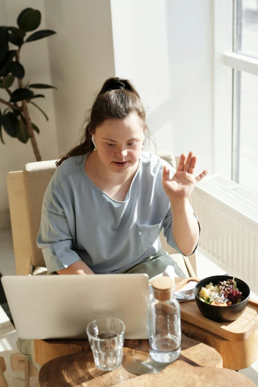 a woman sitting at a table in front of a laptop, surreautistic, people inside eating meals, bella poarch, day time