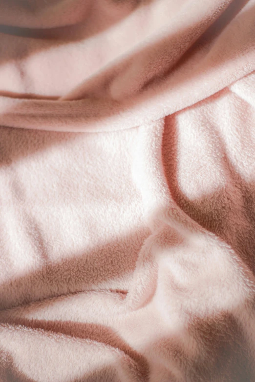 a teddy bear sitting on top of a pink blanket, in the evening, up-close, double layer fold over hem, soft blush