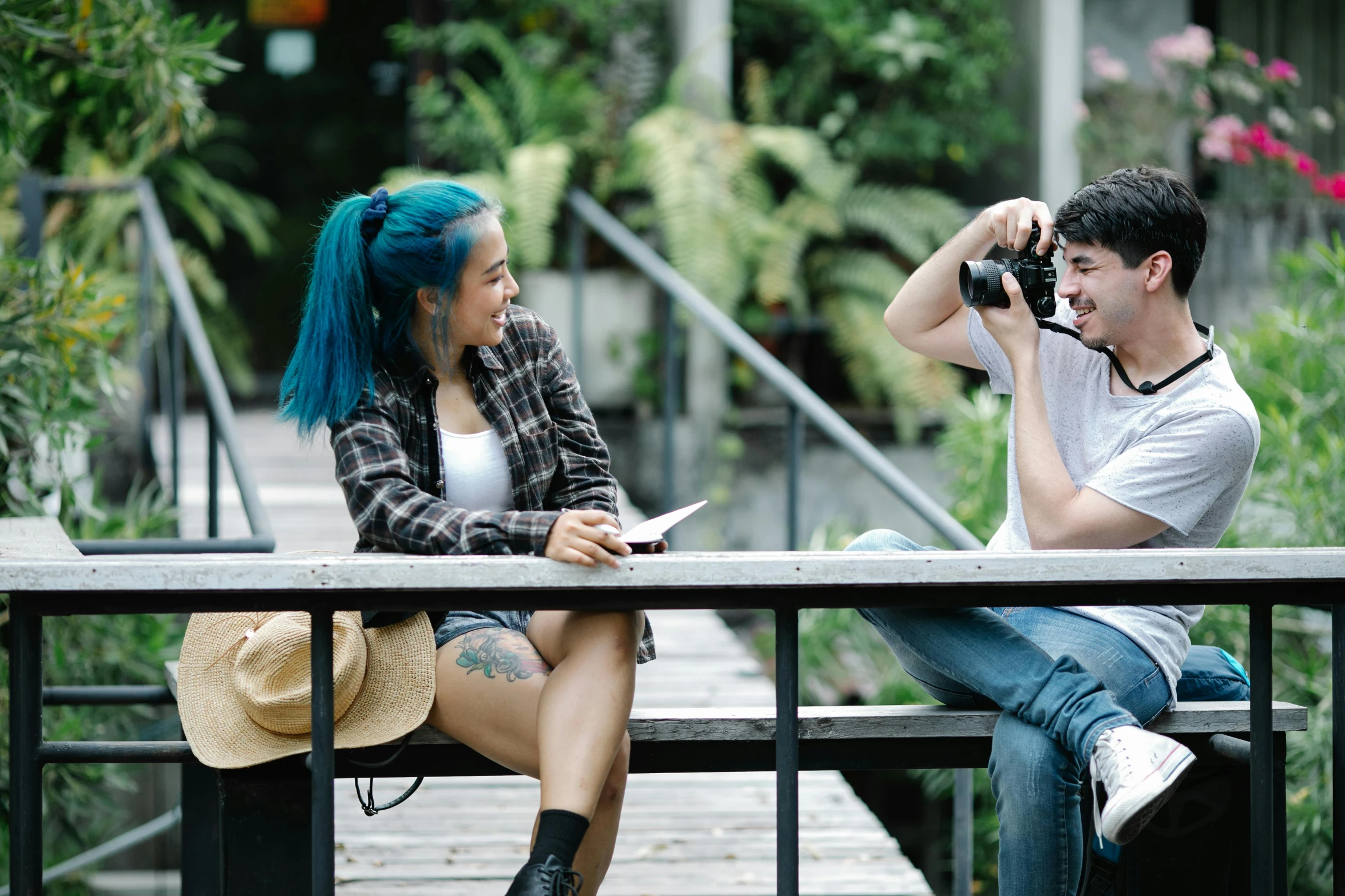 a man taking a picture of a woman with a camera, pexels contest winner, teenager hangout spot, with blue hair, on wooden table, tyler edlin and natasha tan