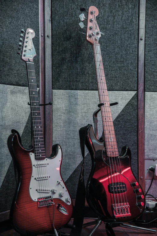 a couple of guitars sitting next to each other, fender stratocaster, studio trigger, upright, evenly lit