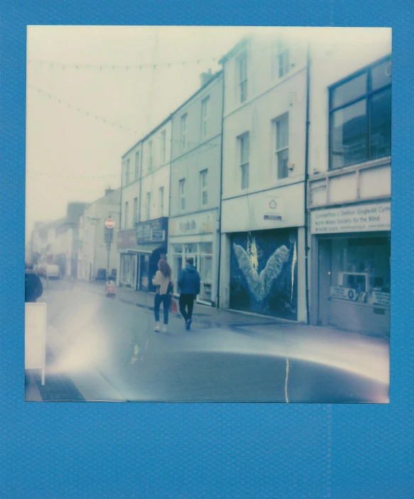a couple of people walking down a street, a polaroid photo, by IAN SPRIGGS, happening, neon blue, maryport, in the middle of the city, slightly pixelated