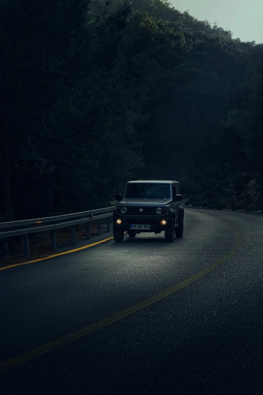 a car driving down a road next to a forest, somber lighting, hasselblad photography, mahindra thar, dark blue