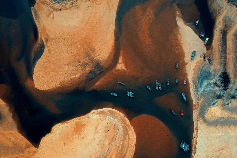 a group of boats sitting on top of a sandy beach, by Daniel Lieske, pexels contest winner, surrealism, taken from orbit, desert colors, thumbnail, chocolate river