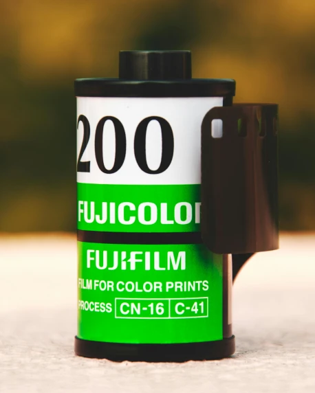 a roll of film sitting on top of a table, by Julia Pishtar, unsplash, color field, green and black color scheme, fuji choco, high resolution film render 100k, fulcolor octane reminder