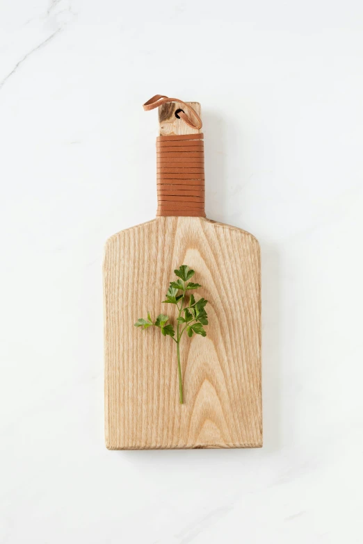 a wooden cutting board with a sprig of parsleya on it, inspired by Carpoforo Tencalla, leather apron, bottle, medium blonde, product view