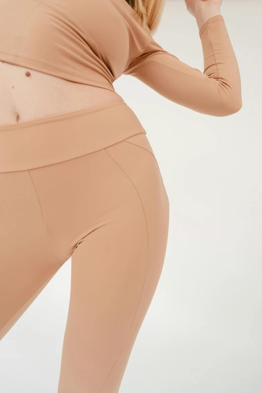 a woman in a tan top and leggings, bottom body close up, fineline detail, product shot, thumbnail