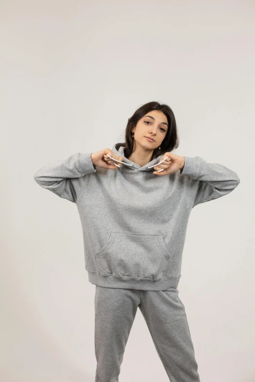 a woman in a grey hoodie poses for a picture, an album cover, by Nina Hamnett, trending on unsplash, seamless, sports clothing, product introduction photo