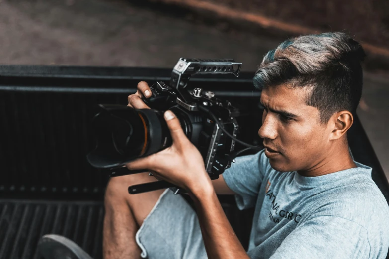 a man sitting in the back of a truck holding a camera, inspired by John Luke, **cinematic, fadeev 8 k, production ig, highly focused