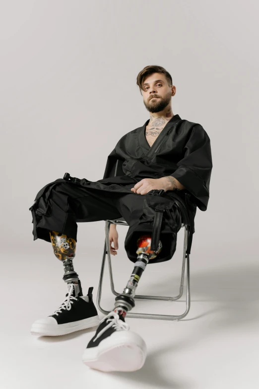 a man with a prosthetic leg sitting in a chair, an album cover, inspired by Seb McKinnon, trending on pexels, hyperrealism, wearing japanese techwear, h3h3, artem demura, lgbtq