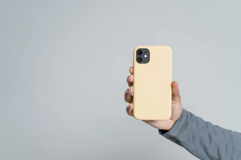 a person holding up a yellow iphone case, pexels, beige mist, square, 12, small