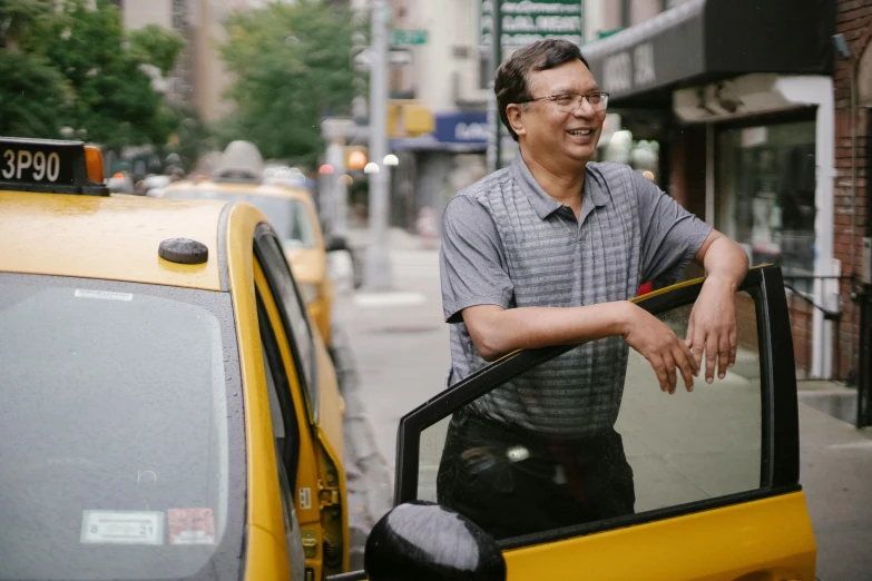 a man standing next to a taxi on a city street, jayison devadas, profile photo, new york times, smiling