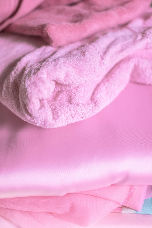 a pile of pink towels sitting on top of a bed, pearlescent skin, detail shots, ((pink)), detailed product image