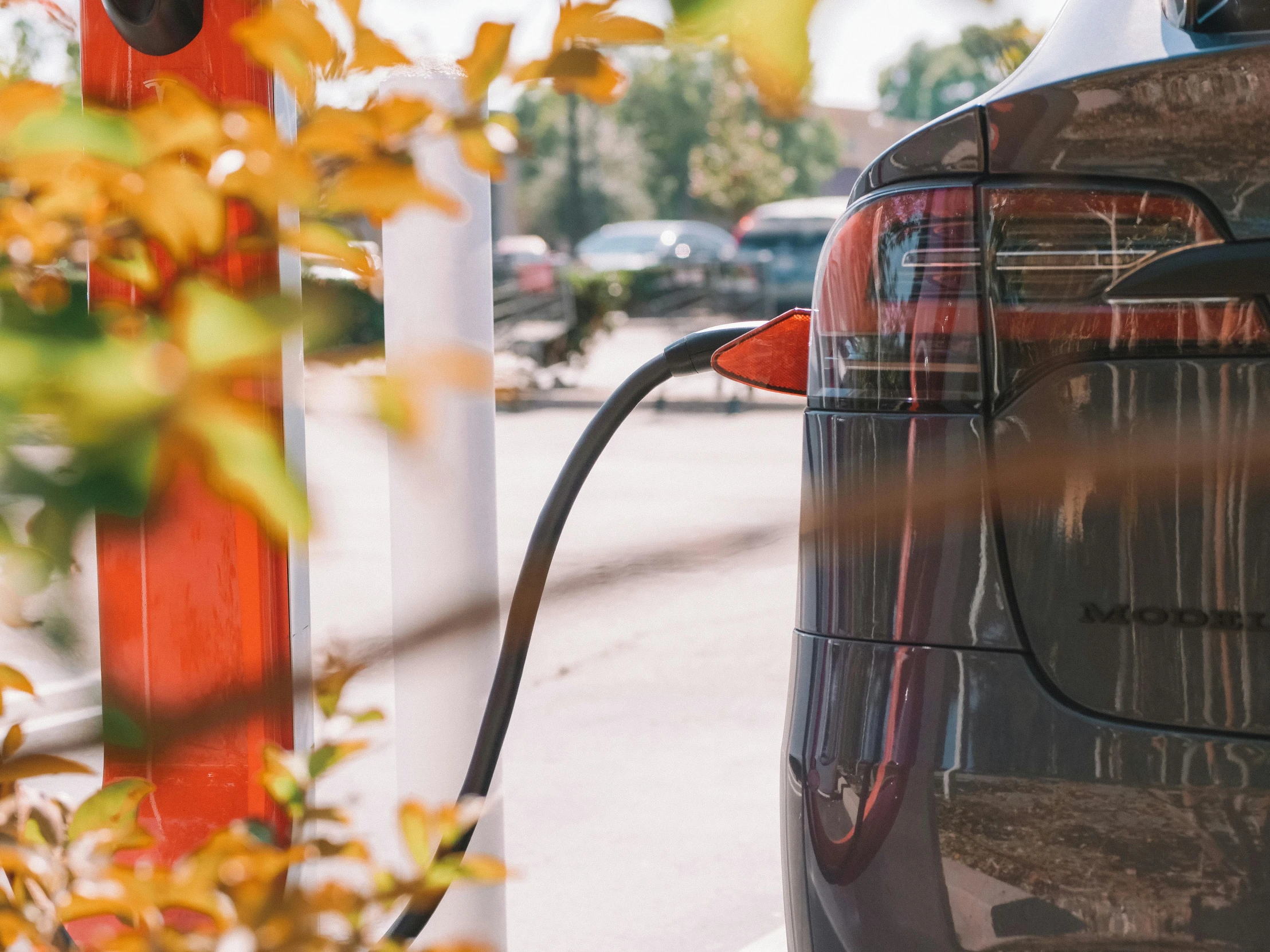 an electric car plugged into a charging station, pexels contest winner, photorealism, 🦩🪐🐞👩🏻🦳, detailed cinematic shot, petrol energy, exterior shot