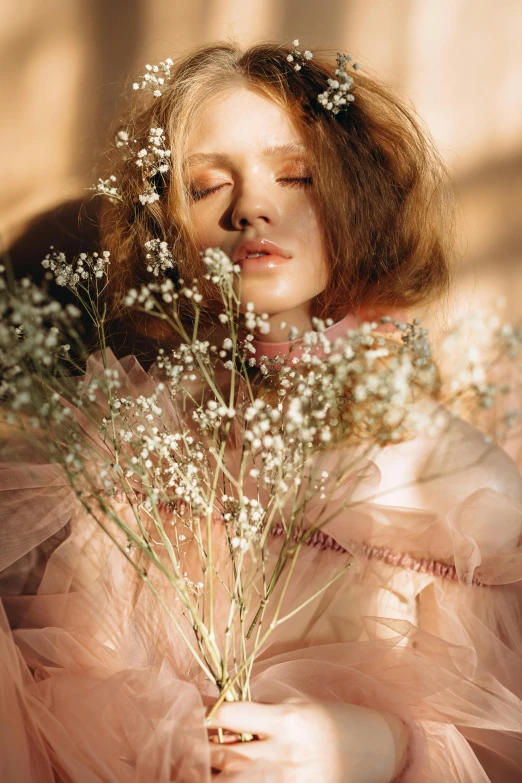 a woman in a pink dress holding a bunch of flowers, a picture, inspired by Elsa Bleda, trending on pexels, romanticism, karol bak of emma watson nun, gypsophila, a redheaded young woman, lulu chen