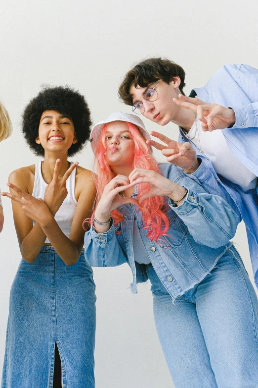 a group of young people standing next to each other, trending on pexels, renaissance, wig, denim, with index finger, pastel clothing