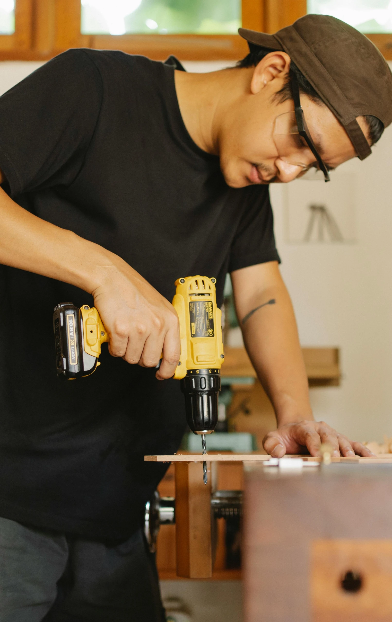 a man using a power drill on a piece of wood, pexels, arbeitsrat für kunst, asian male, yellow, - 9, thumbnail