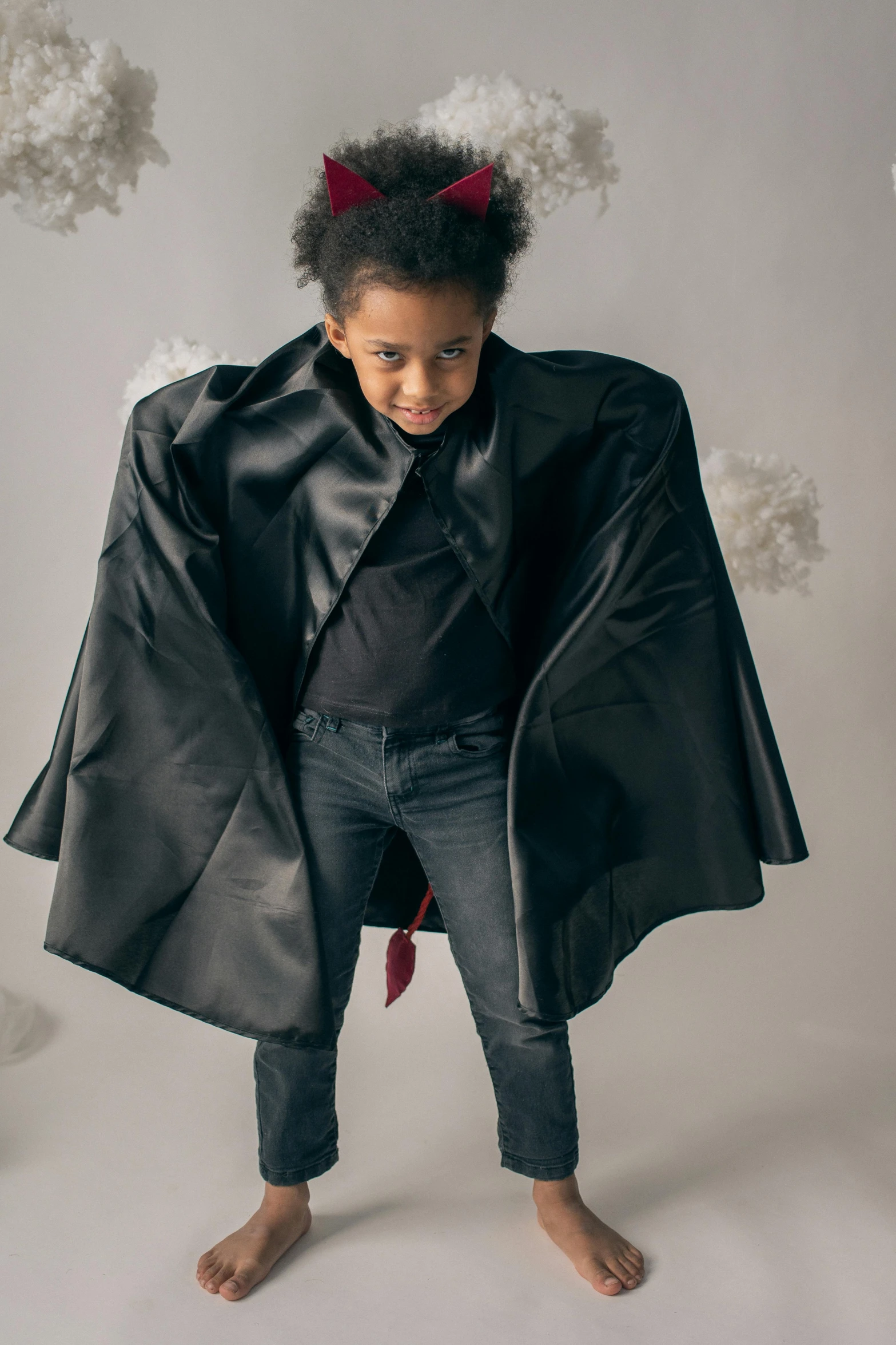 a little girl dressed up as a bat, an album cover, pexels, happening, wearing black leather trenchcoat, black teenage boy, shot from above, super hero pose