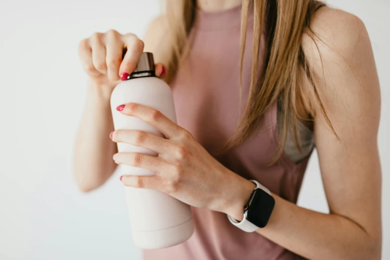 a close up of a person holding a water bottle, trending on pexels, minimalism, white and pink, thinning hair, wearing a watch, fit girl