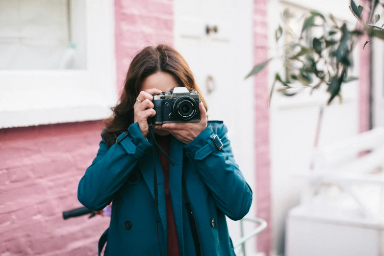 a woman taking a picture with a camera, by Nina Hamnett, wearing blue jacket, cute photograph, multicoloured, rebecca sugar