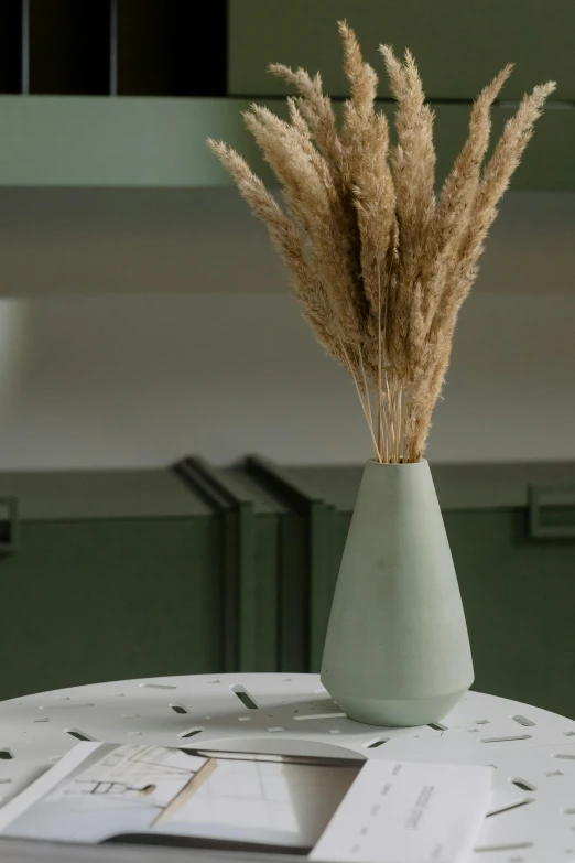 a white table topped with a vase filled with dry grass, a marble sculpture, trending on pexels, seafoam green, detailed cinematic render, cone shaped, high grain