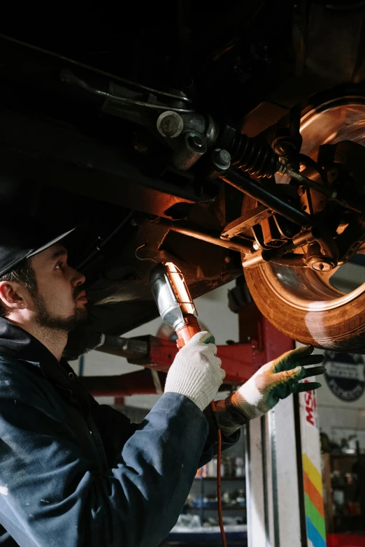 a man working on a vehicle in a garage, pexels contest winner, renaissance, underbody, full dynamic colour, brown, 2 0 % pearlescent detailing