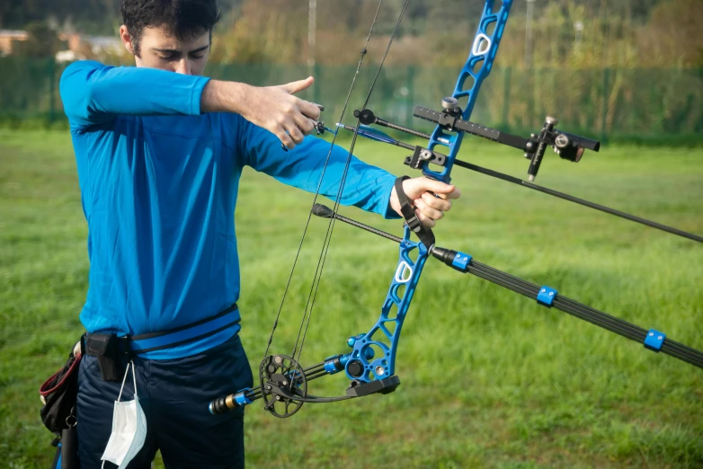 a man that is standing in the grass with a bow, sports setting, mateo dineen, precision, thumbnail