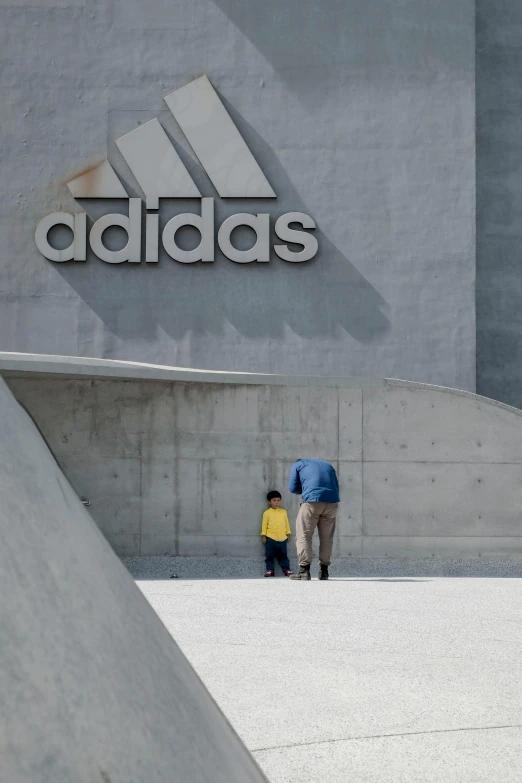 a man riding a skateboard up the side of a ramp, inspired by Tadao Ando, concrete art, new adidas logo design, father with child, at a mall, on a gray background