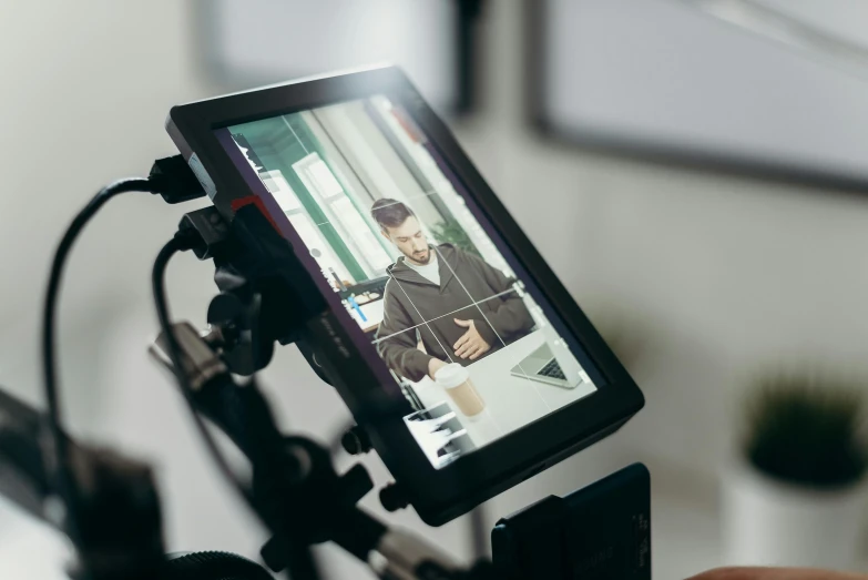 a close up of a person holding a video camera, using a magical tablet, modelling, filmstill, straight on portrait