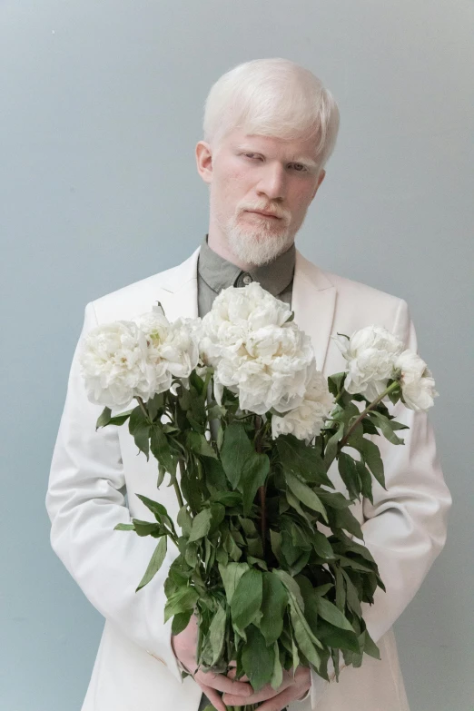 a man in a white suit holding a bouquet of flowers, an album cover, inspired by Petrus Van der Velden, intense albino, ignant, freud lucian, ikebana white flowers