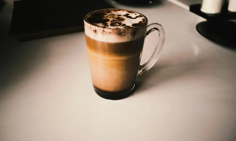 a close up of a cup of coffee on a table, on a white table, nostlagia, multiple stories, milkshake