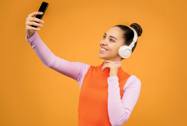 a woman wearing headphones taking a selfie with her cell phone, a picture, trending on pexels, aestheticism, white and orange, photoshoot for skincare brand, frontal pose, various posed