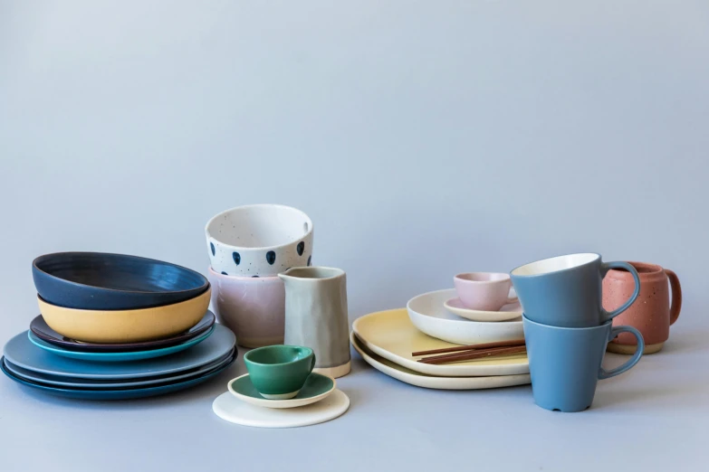 a number of plates and cups on a table, inspired by Lewis Henry Meakin, minimalism, solid colours material, irregular, from left, pastel deep colours