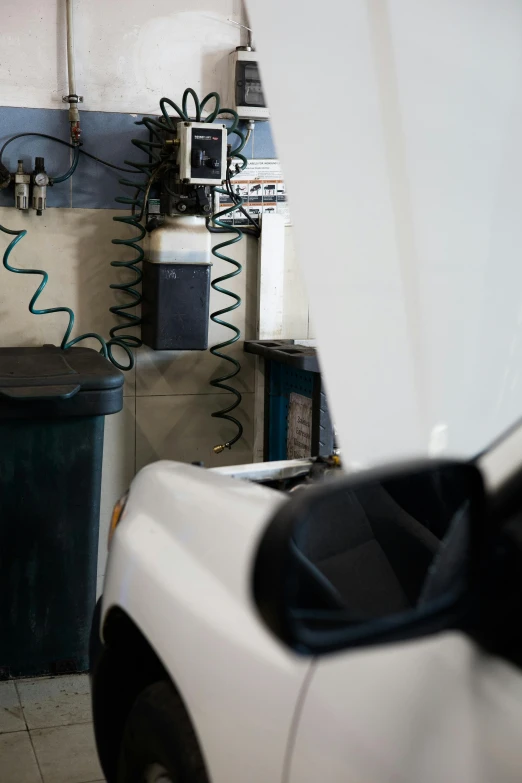 a white truck parked in a garage next to a trash can, by Joe Stefanelli, unsplash, les automatistes, charging plug in the chest, photographed for reuters, embedded in clear epoxy, thumbnail