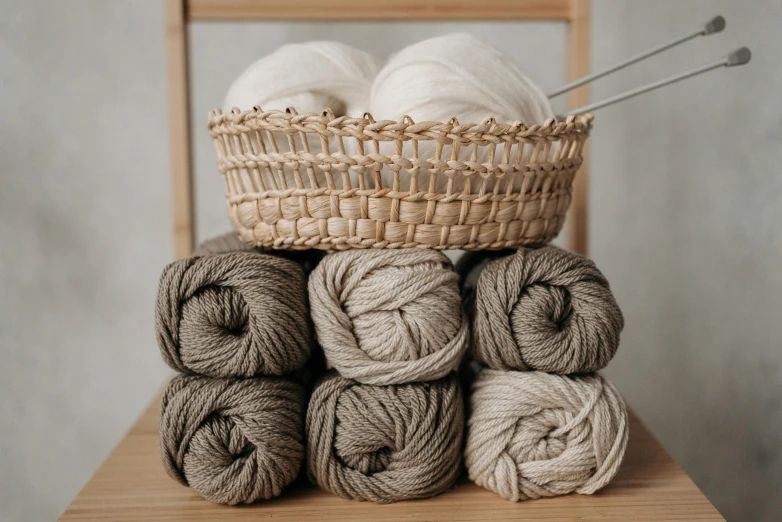 a basket of yarn sitting on top of a wooden chair, taupe, thumbnail, no color