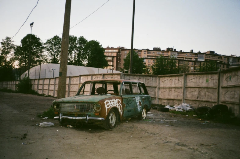 a car that is sitting in the dirt, inspired by Elsa Bleda, unsplash, graffiti, soviet suburbs, analogue photo, a wooden, 90s photo