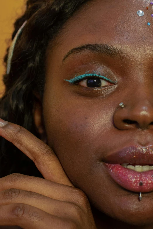 a close up of a person with glitter on her face, an album cover, by Nathalie Rattner, trending on pexels, afrofuturism, teal eyebrows, black teenage girl, relaxed eyebrows, porcelain skin ”