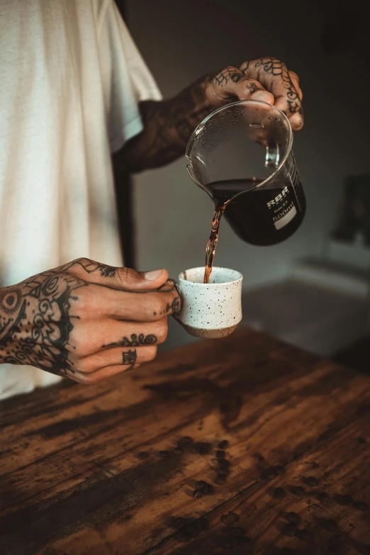 a tattooed man pouring coffee into a cup, pexels contest winner, instagram story, heavily upvoted, black hands with black claws, hygge