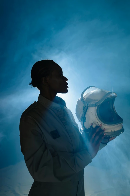 a man in a space suit holding a helmet, trending on unsplash, afrofuturism, portrait of mad lady scientist, kara walker, profile image, 2019 trending photo