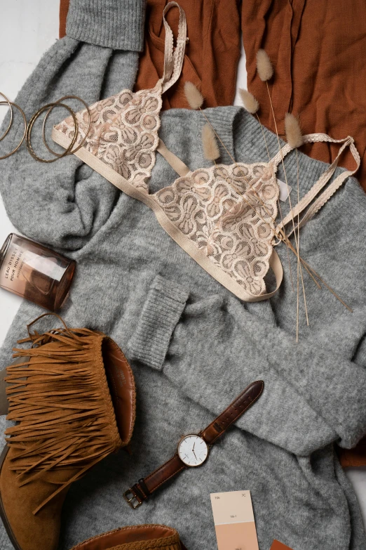 women's clothing and accessories laid out on a bed, inspired by Jeanne du Maurier, trending on pexels, renaissance, grey sweater, bralette, caramel, seducing