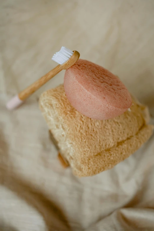 a toothbrush sitting on top of a stack of towels, inspired by Jacopo Bellini, renaissance, covered with pink marzipan, one sandwich with fried tofu, spoon placed, dry brushing