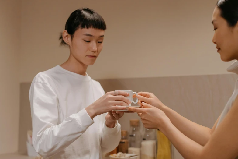 a woman putting a ring on another woman's finger, pexels contest winner, hyperrealism, holding a boba milky oolong tea, zeen chin and terada katsuya, inspect in inventory image, smooth porcelain skin