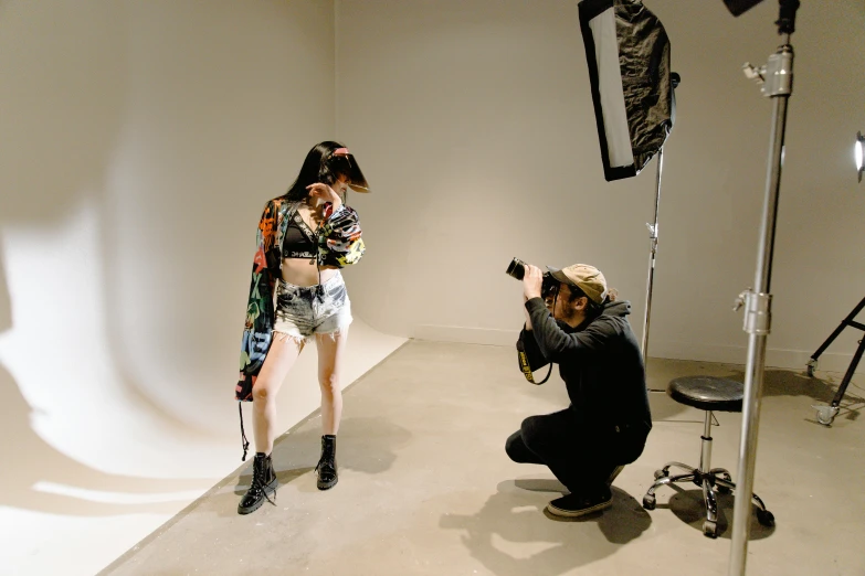 a man taking a picture of a woman in a photo studio, by Robbie Trevino, japanese streetwear, studio medium format photograph, bella poarch, bts