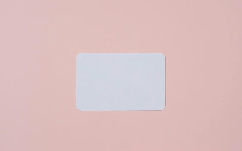 a piece of paper sitting on top of a pink surface, rounded corners, card back template, product image, white plastic