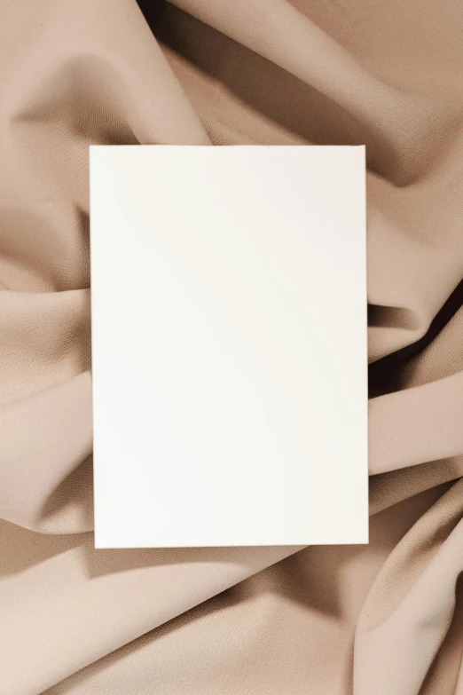 a white box sitting on top of a brown cloth, trending on pexels, ui card, made of silk paper, gradient, photograph ”