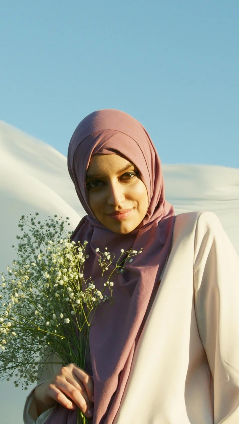 a woman in a hijab holding a bunch of flowers, a colorized photo, pexels contest winner, hurufiyya, light blush, 15081959 21121991 01012000 4k, confident smirk, summer evening